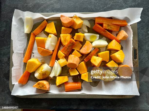 raw vegetables on a baking tray ready to be roasted. - root vegetable stockfoto's en -beelden