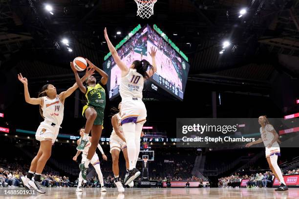 Kaila Charles of the Seattle Storm shoots against Sam Thomas and Megan Gustafson of the Phoenix Mercury during the first quarter in a WNBA preseason...