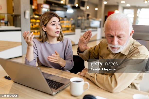 two business people having an argument at coffee shop - boss angry stockfoto's en -beelden