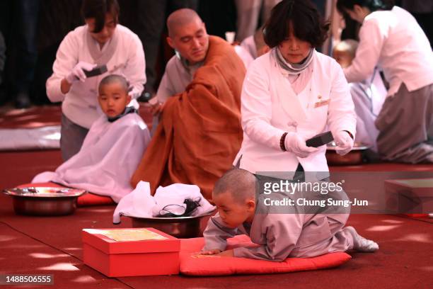 Children get their head shaved by a Buddhist monk during a ceremony to prepare children to live as Buddhist monks for three weeks at Jogyesa Temple...