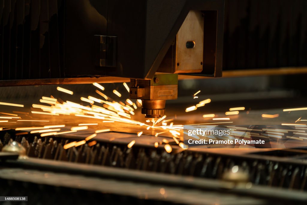 Cutting of metal. Sparks fly from laser. CNC Laser cutting of metal. modern industrial technology. Steel Laser Cutting Machine. Industrial machinery and technology concepts.
