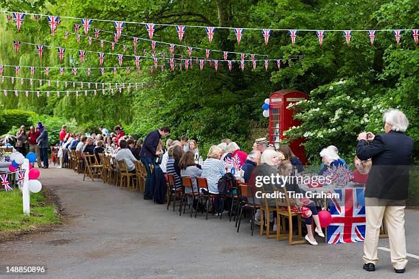 Street party with Union Jack flags and bunting to celebrate Queen's Diamond Jubilee at Swinbrook in The Cotswolds, UK