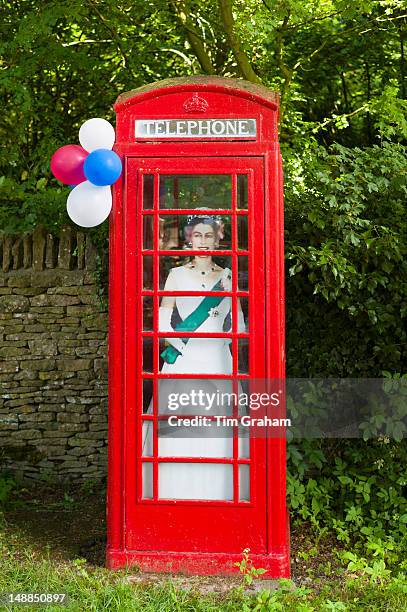 Cutout image of Queen Elizabeth II in phonebox at street party to celebrate the Diamond Jubilee in Swinbrook in the Cotswolds, UK