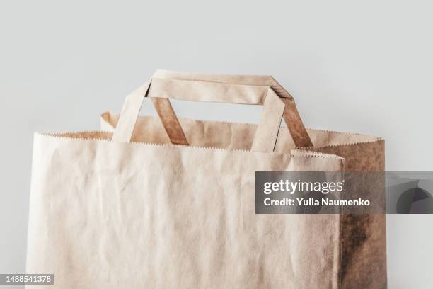 empty disposable brown kraft paper bag with handles. - sachet en papier photos et images de collection