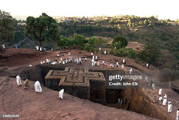 worshipers beside cross shaped roof of bet giyorgis church. - lalibela foto e immagini stock