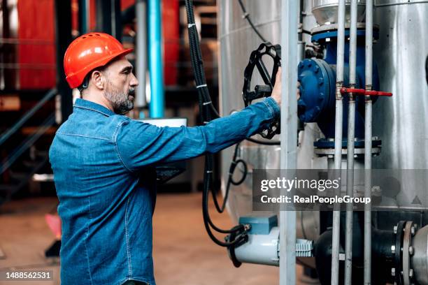 heating plant engineer checking the valve - gasturbine stockfoto's en -beelden