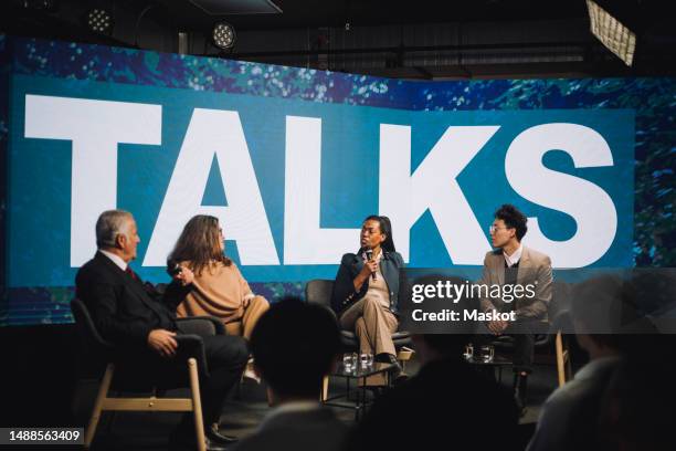 male and female business persons discussing with each other during panel discussion at convention center - entrevista evento imagens e fotografias de stock