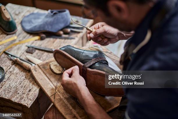 close-up of shoemaker working on shoe in his workshop - sapateiro imagens e fotografias de stock