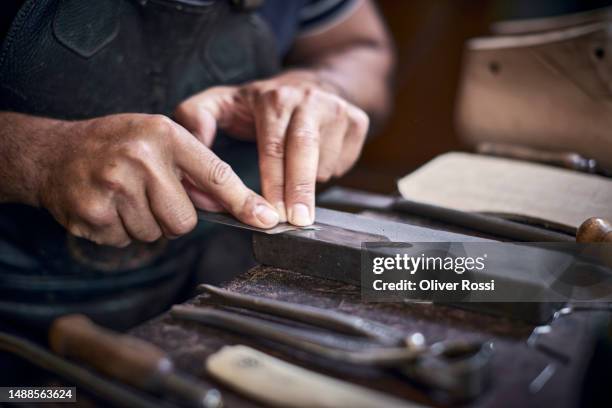 close-up of shoemaker measuring on workbench in his workshop - hand tool stock-fotos und bilder