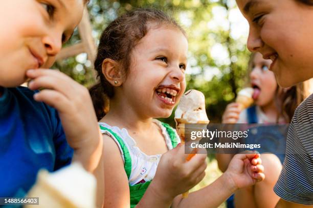 smiling group of children eating ice cream - girl eating messy ice cream cone stock pictures, royalty-free photos & images