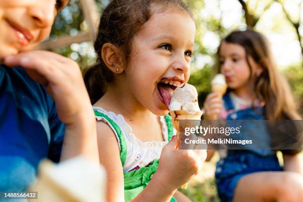 lächelnde gruppe von kindern, die eis essen - girl eating messy ice cream cone stock-fotos und bilder