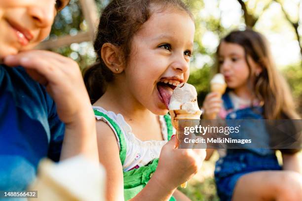 smiling group of children eating ice cream - girls licking girls stock pictures, royalty-free photos & images