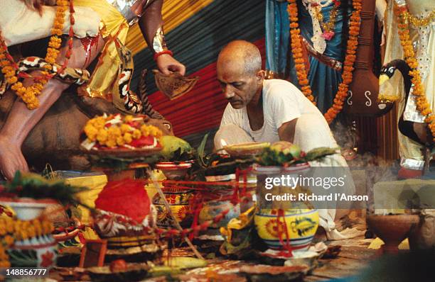 hindu holy man prepares for puja (prayers) during  festival of dussehra, known as durga puja. - saraswati puja festival preparation photos et images de collection