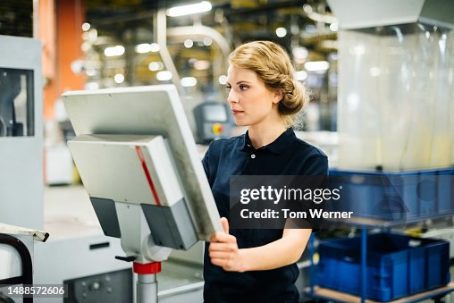 Female Technician programming on control panel Female Technician programming on control panel