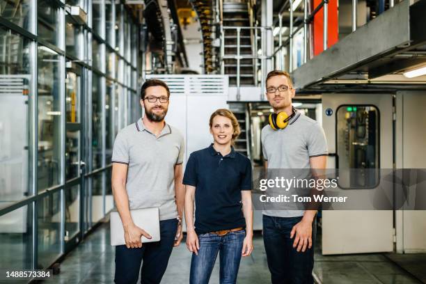 small group of engineers and factory staff standing together - three storey stock pictures, royalty-free photos & images