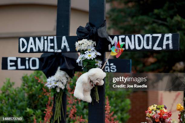 The names of victims are written on crosses setup in a memorial near the scene of a mass shooting at the Allen Premium Outlets mall on May 9, 2023 in...