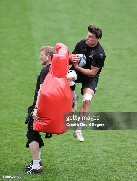 Northampton Saints head coach, Sam Vesty, holds the bag as George Furbank catches the ball during the Northampton Saints training session held at...