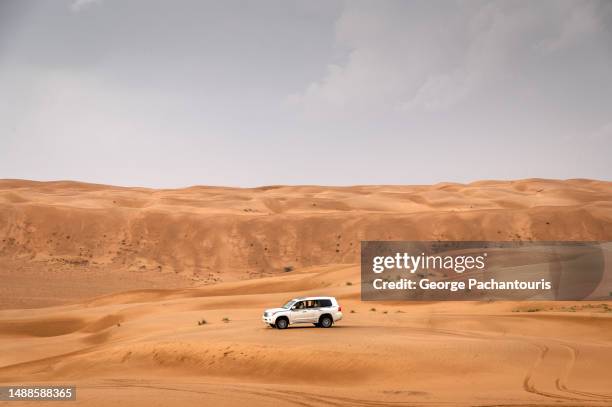 off road vehicle in the dessert sands - atv sand dune stock pictures, royalty-free photos & images