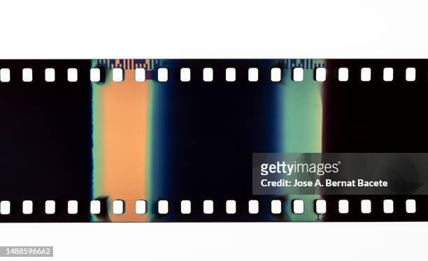 color negative 35mm film stripes on a white background. - diastreifen stock-fotos und bilder