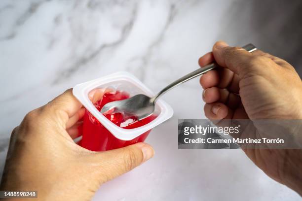 woman eating red gelatin. - gelatin mold fotografías e imágenes de stock