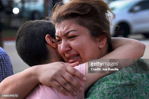Nisreen Hajaj is comforted as she becomes emotional during a visit to the memorial setup near the scene of a mass shooting at the Allen Premium...
