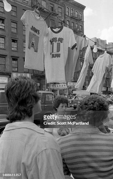 View, between customers, of a vendor at their t-shirt stall on Canal Street , in the Little Italy neighborhood, New York, New York, September 13,...