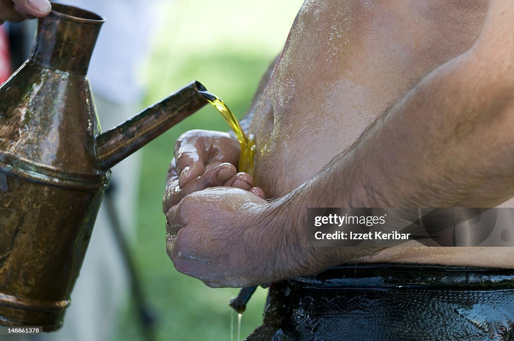 Wrestler pouring olive oil on himself at Edirne 2008 Kirkpinar oil wrestling tournament.