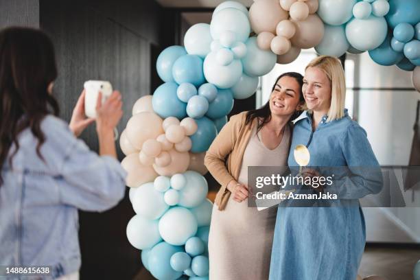 taking polaroid photos at a baby shower celebration - babyshower bildbanksfoton och bilder