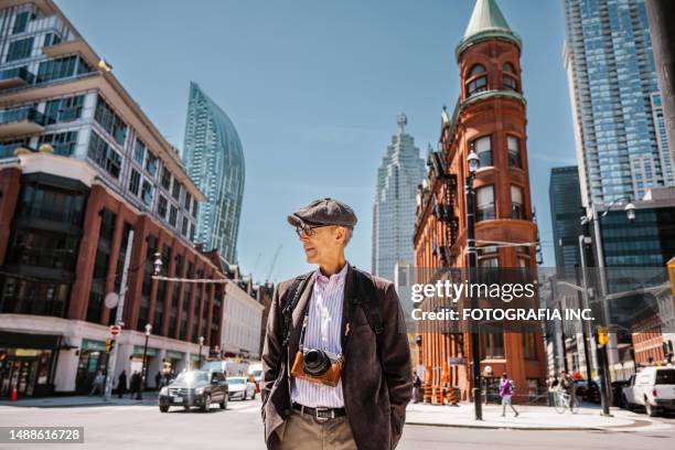 un homme âgé visitant le centre-ville de toronto - toronto photos et images de collection