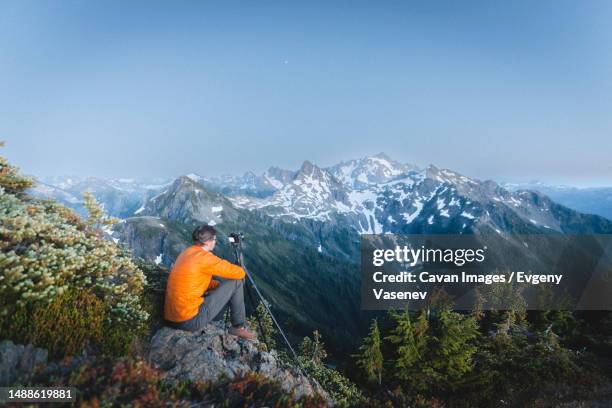 a man with a camera is taking pictures of mountains in north cascades - wanderweg-pacific-crest-trail stock-fotos und bilder