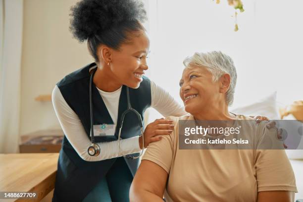 senior woman, caregiver and healthcare in a nursing home with communication or support. elderly female patient with nurse for healing, trust and empathy or therapy with health insurance and happiness - vrijwilliger bedrijf stockfoto's en -beelden
