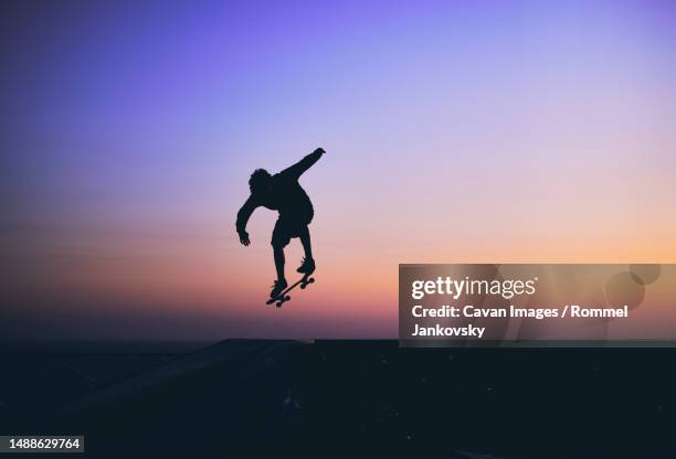 skateboarder in action, silhouette unrecognizable - skateboarding silhouette stock pictures, royalty-free photos & images