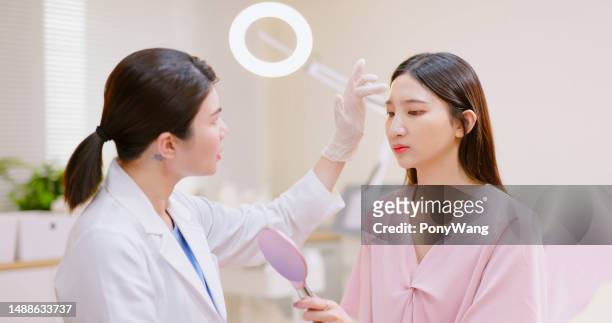 woman ask face aesthetic treatment - dermatologists talking to each other patient stock pictures, royalty-free photos & images