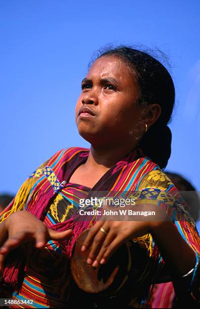 young timorese girl beating drum during traditional dance performance. - east timor stock pictures, royalty-free photos & images