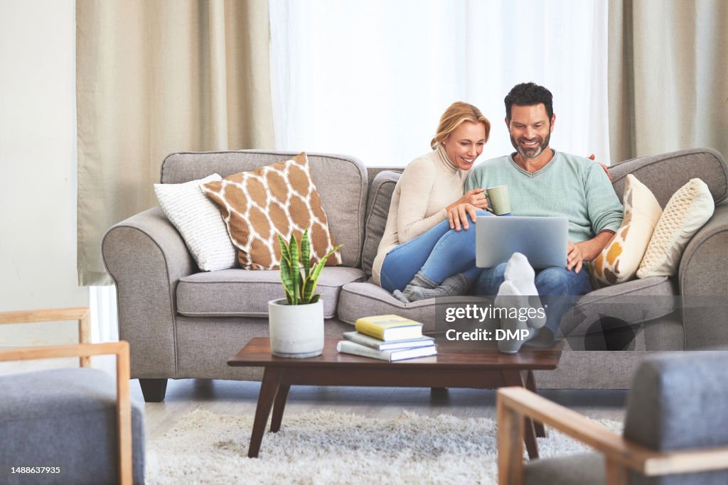 Coffee, couple and happy with laptop in living room of home, bonding and relaxing. Tea, couch and man and woman with computer, watching and streaming video, film or movie together on sofa in house.