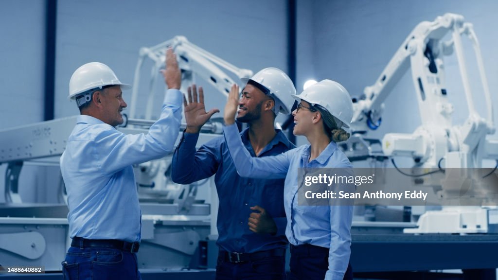 High five, robotics and engineering people with factory teamwork, success or celebration in industry 4.0 design. Diversity group of technician, woman and men hands together for machine or electronics