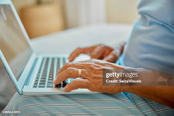 senior man, laptop typing and hands with life insurance research on living room sofa for funeral coverage. online, internet and website of elderly person checking investment planning for retirement. - begrafenis stockfoto's en -beelden