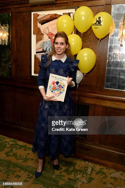 Princess Beatrice poses with Jarvis's winning book 'The Boy With Flowers in His Hair' during the Oscar's Book Prize Winner Announcement at The Ivy on...