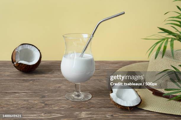 a glass of coconut milk cocktail on wooden table,france - lassi stock pictures, royalty-free photos & images