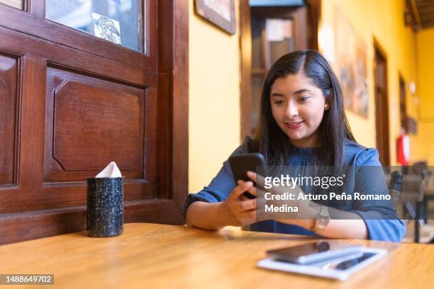 mujer joven trabajando a distancia en un café - indigenas mexicanos fotografías e imágenes de stock