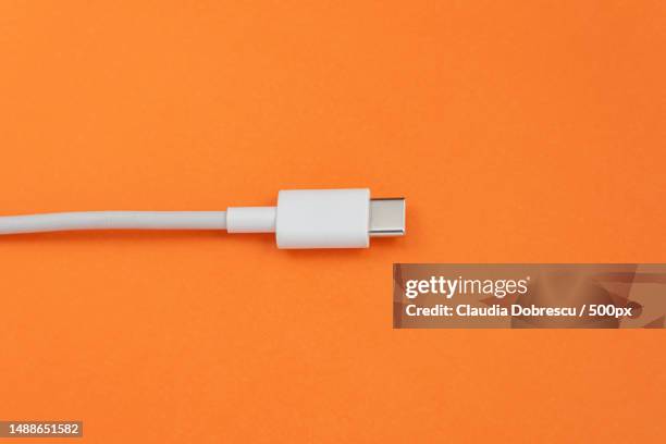usb cable type c over orange background,romania - usb cable stock pictures, royalty-free photos & images