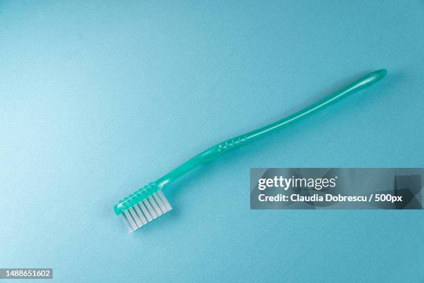 high angle view of toothbrush on blue background,romania - fluor stockfoto's en -beelden