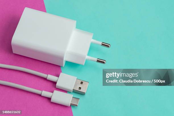 charger and usb cable type c over pink and blue background,romania - chargeur de batterie photos et images de collection