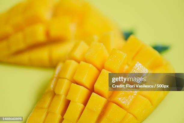 mango slice tropical summer fruit concept - close up of sweet ripe mangos cut half,romania - mango piece stock-fotos und bilder