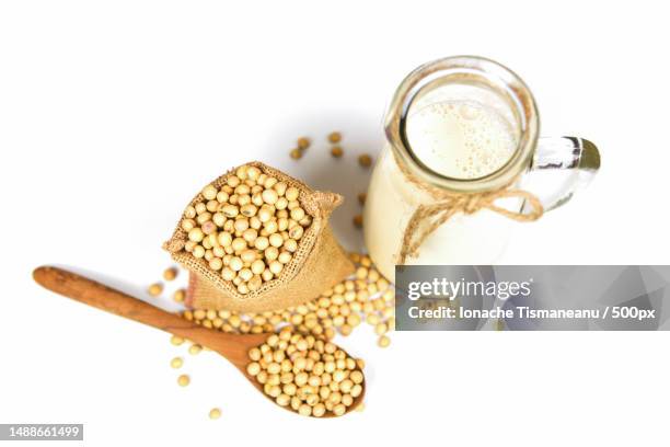 soy milk in glass jar for healthy diet and natural bean protein - soybean on wooden spoon and dried soy beans in the sack isolated on white background,romania - sojamilch stock-fotos und bilder