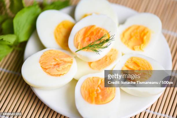 eggs breakfast,fresh eggs menu food boiled eggs in a white plate decorated with leaves green dill background,cut in half egg yolks for cooking healthy eating,romania - hard boiled eggs stock-fotos und bilder