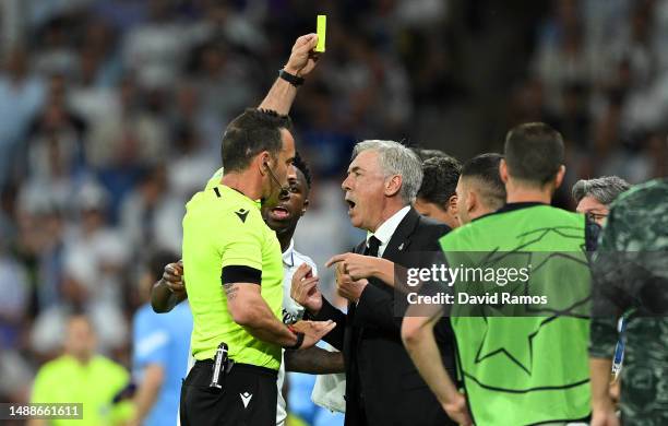 Referee Artur Dias Soares shows a yellow card to Carlo Ancelotti, Head Coach of Real Madrid, after Kevin De Bruyne of Manchester City scored the...