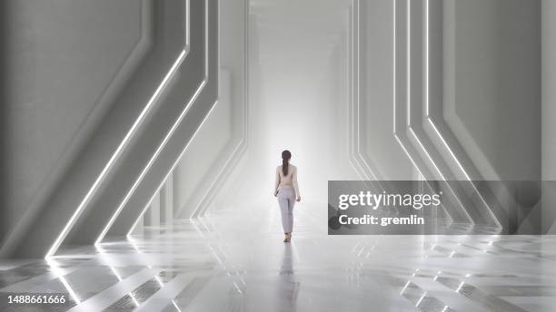 woman walking in futuristic corridor - urban simplicity stock pictures, royalty-free photos & images
