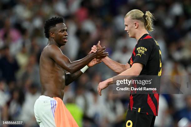 Vinicius Junior of Real Madrid embraces Erling Haaland of Manchester City after the draw during the UEFA Champions League semi-final first leg match...