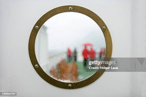 wet view through porthole to deck on cruiseship ms deutschland (reederei deilmann), beagle channel. - bullauge stock-fotos und bilder
